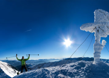 Thumbnail http://Skitourengeher%20am%20Gipfelkreuz%20bei%20Sonnenschein