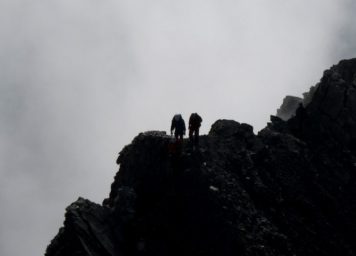 Thumbnail http://Silhouetten%20von%20zwei%20Bergsteiger%20mit%20Nebel