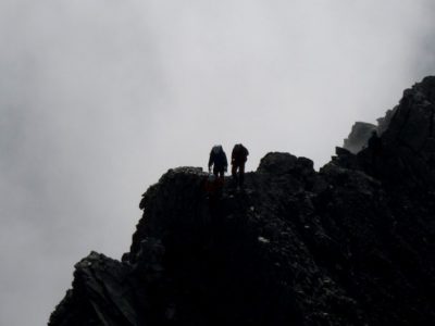 Silhouetten von zwei Bergsteiger mit Nebel