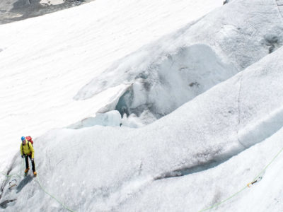 Zwei Hochtourengeher im Eis, lernen das Pickeln und die Steigeisentechnik in einer Eisflanke.