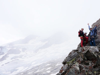 Dreierseilschaft auf Felsgrat in den Hohen Tauern hinter der Neuen Prager Hütte in schönem Gneis Gestein.
