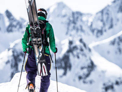 Hike and Ride am Arlberg in Tirol (Österreich), Freerider trägt seine Freerideski zum Abfahrtspunkt.