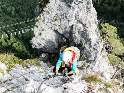 Frau bei Seilbrücke und Klettersteig mit Tiefblick