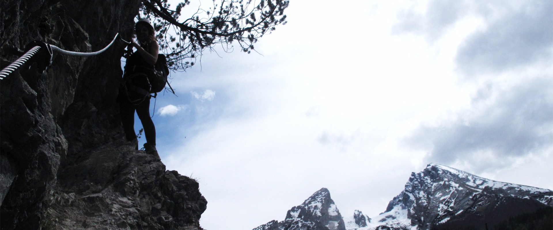 Silvana Steinhöfel bei einem Klettersteig mit dem Watzmann, Hocheck und dem Kleinen Watzmann im Hintergrund