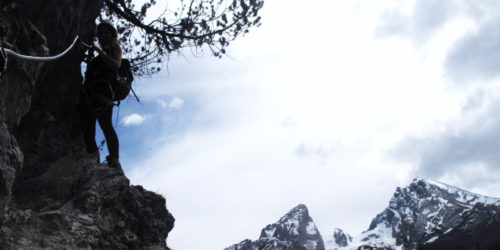 Silvana Steinhöfel bei einem Klettersteig mit dem Watzmann, Hocheck und dem Kleinen Watzmann im Hintergrund