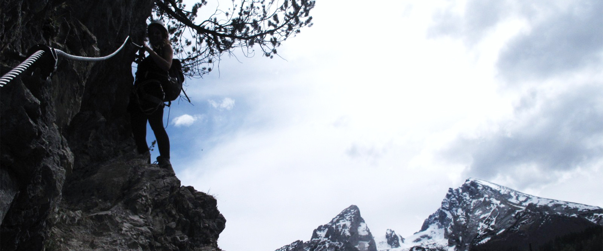 Silvana Steinhöfel bei einem Klettersteig mit dem Watzmann, Hocheck und dem Kleinen Watzmann im Hintergrund