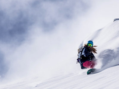 Snowboarderin im Tiefschnee unterwegs