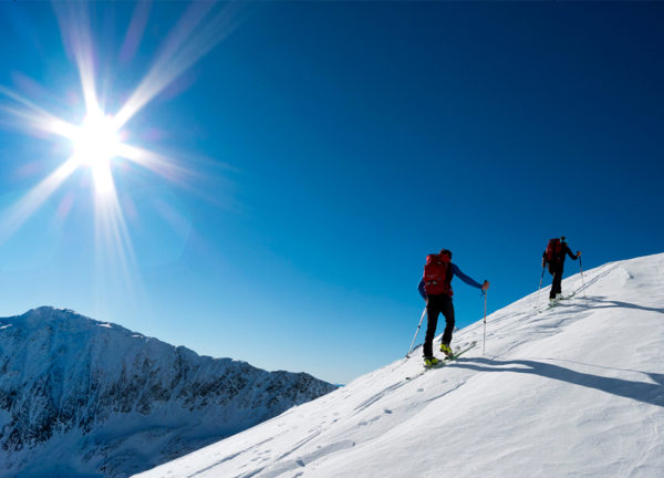 Zwei Skitourengeher im Aufstieg in verschneiter Winterlandschaft
