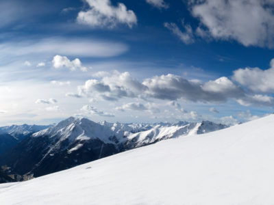 Skifahrer mit Panorama und Schäfchenwolken am blauen Himmel