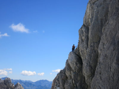 Klettersteiggeherin im Schultersteig am Dachstien mit Felswand und Panorama