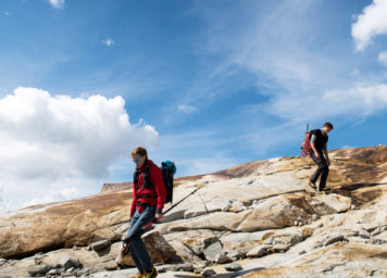 Thumbnail http://Zwei%20Bergsteiger%20gehen%20auf%20rötlichem%20Gneisgletscherschliff-Platten